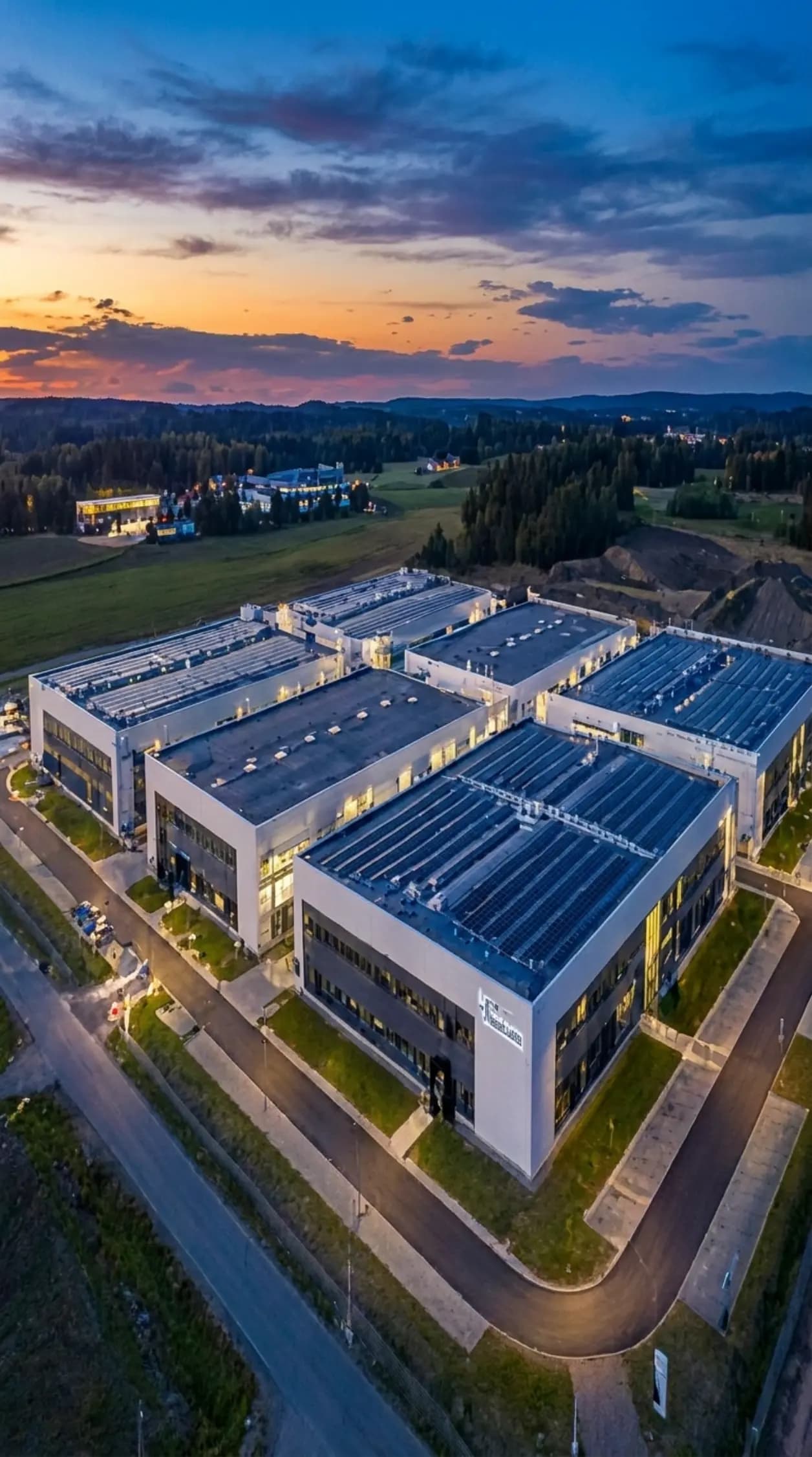 Aerial view of a manufacturing campus with rooftop solar at dusk